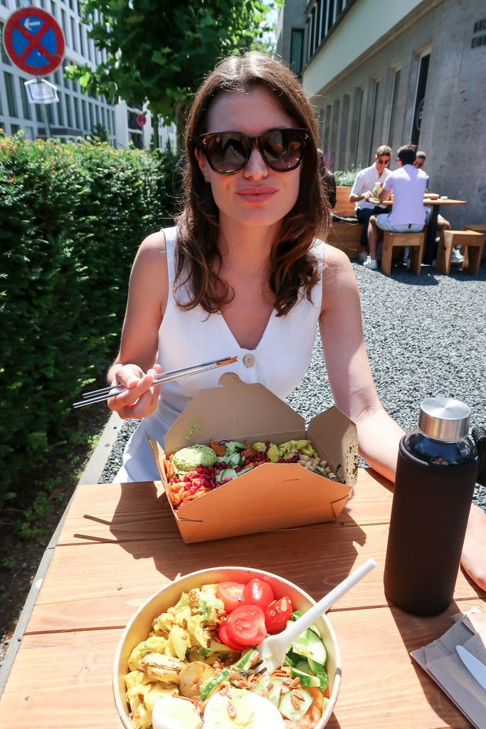 girl enjoying plastic free cutlery eating food in the sun